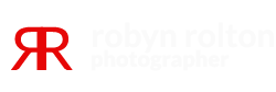 Minimalist Robyn Rolton Photography logo featuring a ribbon-styled camera icon.